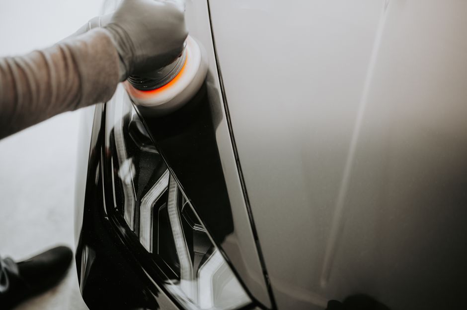 Professional applying ceramic coating to a luxury vehicle